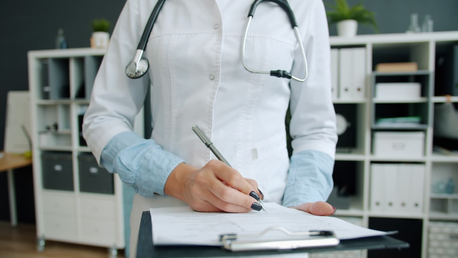 Médecin signant un document dans un cabinet médical