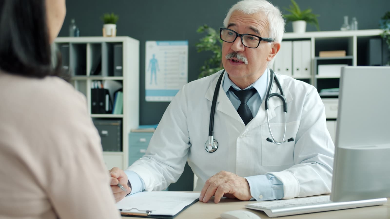 Médecin en blouse blanche recevant un patient en consultation